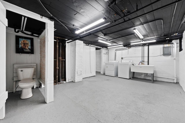 unfinished below grade area featuring a sink, separate washer and dryer, and electric panel