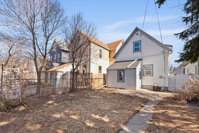 rear view of house with roof with shingles and fence