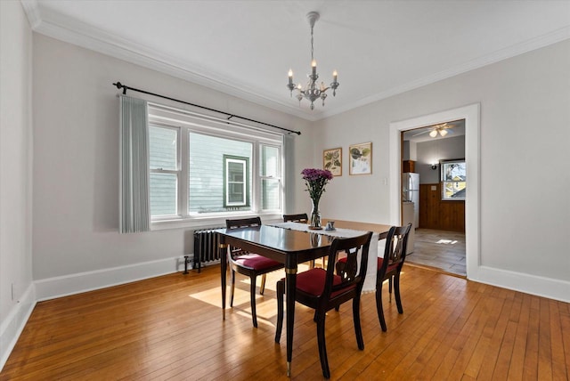 dining area with a wealth of natural light, a chandelier, crown molding, and light wood finished floors