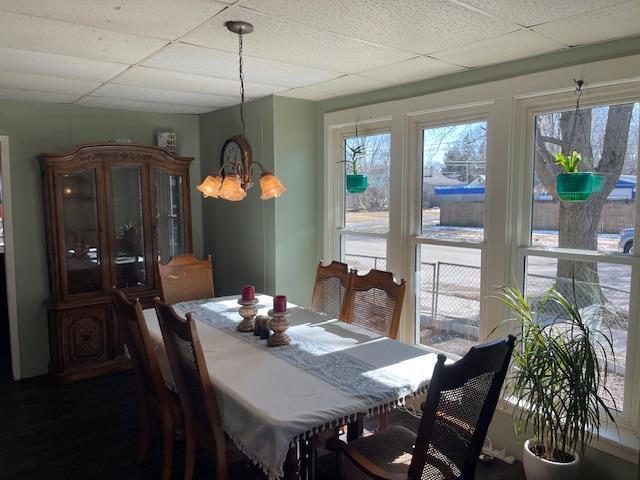 dining space featuring a drop ceiling and a chandelier