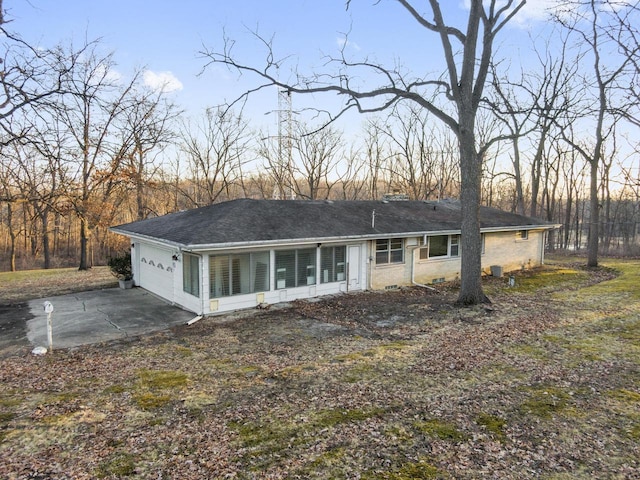 back of property featuring driveway and a garage