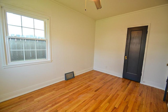 unfurnished room with baseboards, a ceiling fan, light wood-style flooring, and crown molding