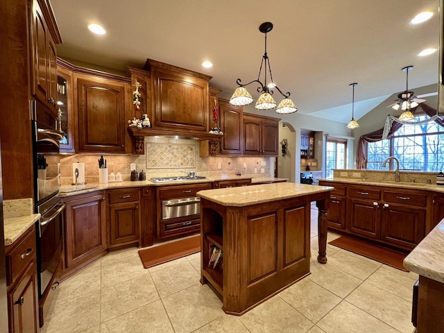 kitchen featuring a warming drawer, a sink, arched walkways, light tile patterned floors, and decorative backsplash