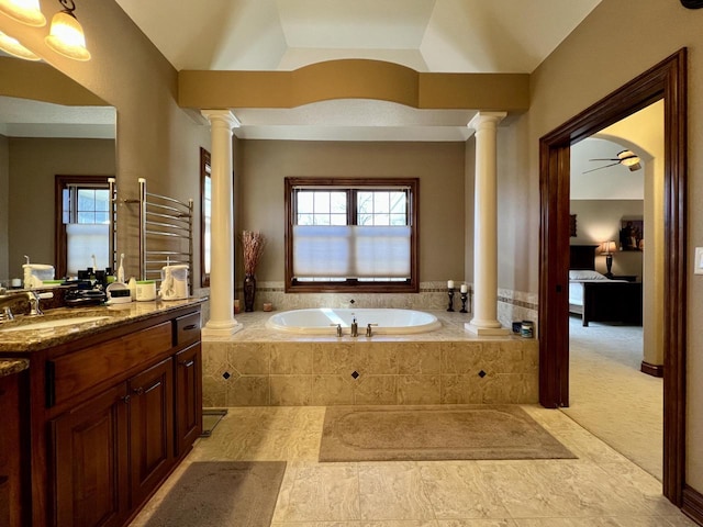 full bath with a wealth of natural light, decorative columns, and a bath