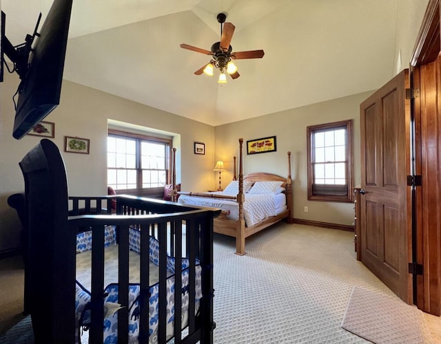 bedroom featuring multiple windows, light colored carpet, baseboards, and vaulted ceiling