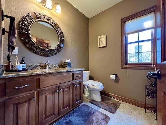 bathroom with vanity, toilet, and baseboards