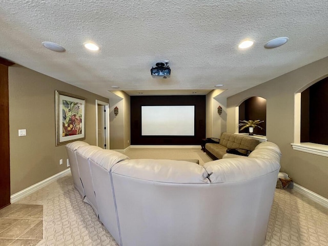 cinema room featuring arched walkways, recessed lighting, baseboards, and a textured ceiling