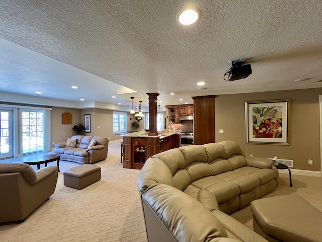 living room with visible vents, baseboards, decorative columns, light carpet, and recessed lighting