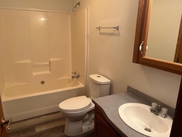 bathroom with shower / bathing tub combination, toilet, wood finished floors, and vanity