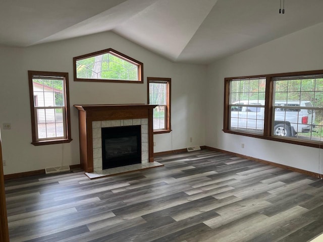 unfurnished living room with visible vents, a fireplace, lofted ceiling, and wood finished floors