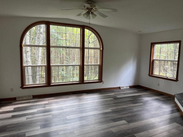 unfurnished room featuring visible vents, baseboards, wood finished floors, and a ceiling fan