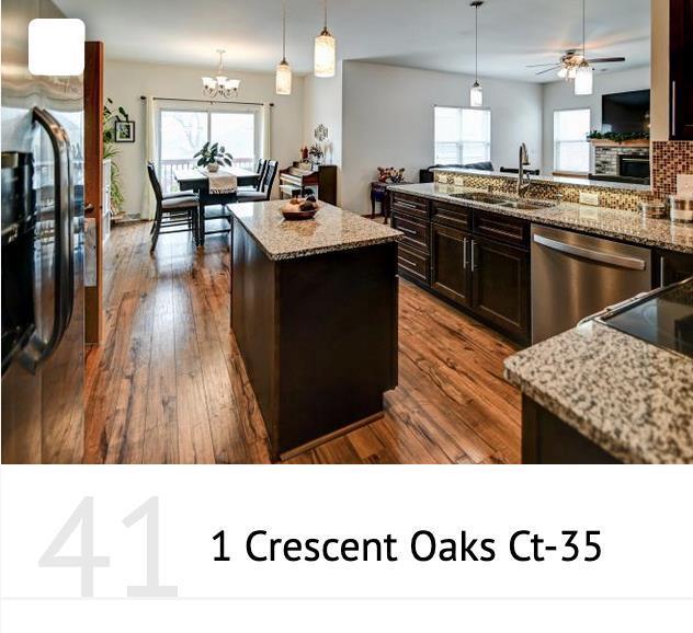 kitchen featuring a sink, a center island, dishwasher, freestanding refrigerator, and dark wood-style flooring