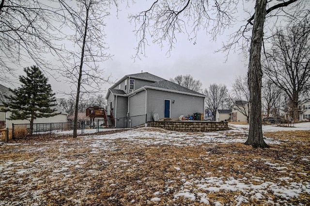 snow covered property with fence