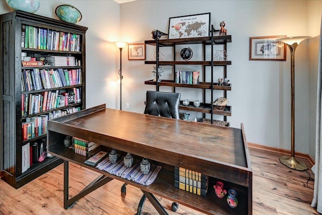 home office with baseboards and wood finished floors