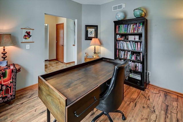 office area featuring visible vents, baseboards, and wood finished floors