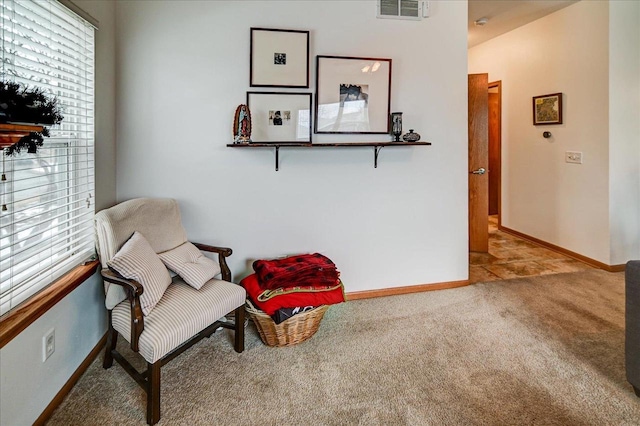 living area with visible vents, baseboards, a healthy amount of sunlight, and carpet flooring