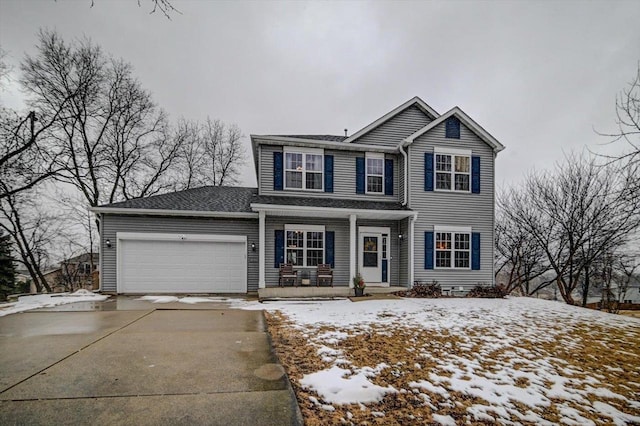 traditional home featuring a garage, covered porch, and driveway