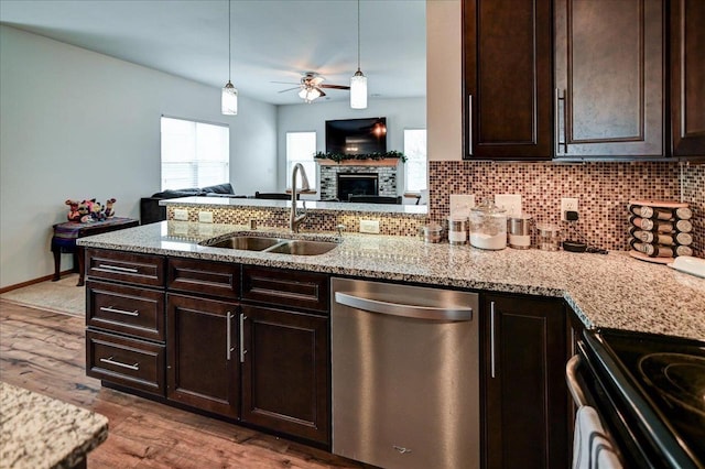 kitchen with open floor plan, decorative backsplash, a peninsula, stainless steel dishwasher, and a sink