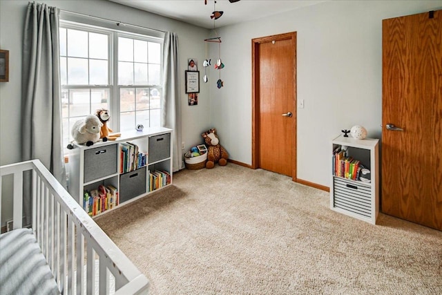 carpeted bedroom with a nursery area and baseboards