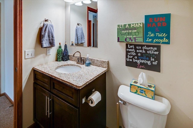 bathroom featuring baseboards, toilet, and vanity