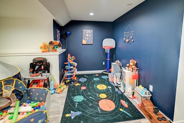 recreation room with lofted ceiling, wood finished floors, and baseboards