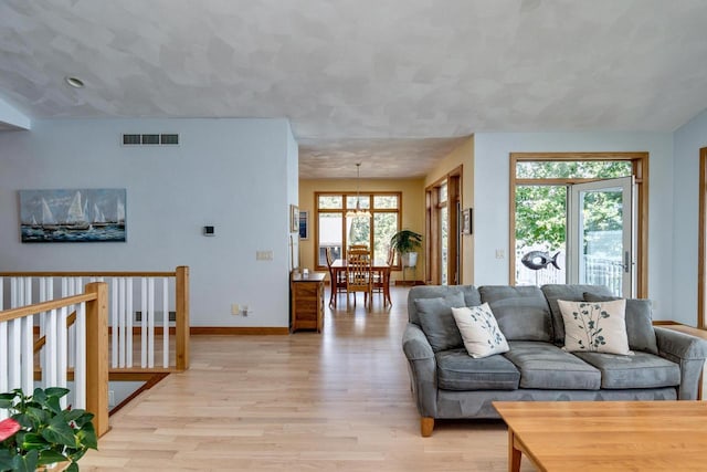 3018 Waubesa Ave, Madison, WI 53711 - living room with light wood-style floors, baseboards, and a chandelier
