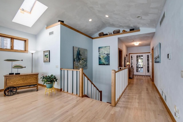 3018 Waubesa Ave, Madison, WI 53711 - corridor featuring an upstairs landing, a skylight, light wood-type flooring, high vaulted ceiling, and baseboards