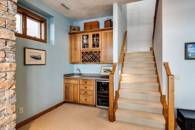 3018 Waubesa Ave, Madison, WI 53711 - indoor wet bar with wine cooler, light carpet, stairway, and baseboards
