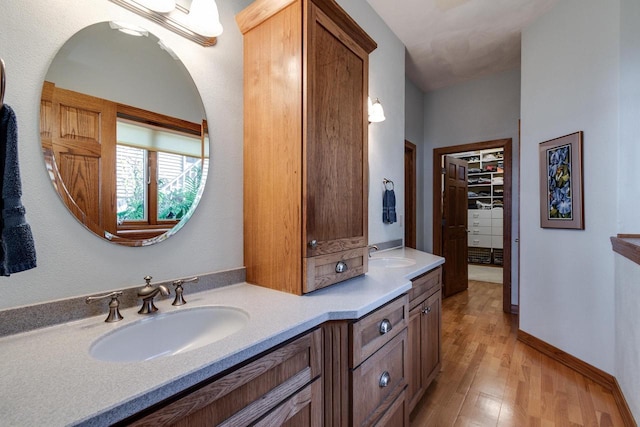 3018 Waubesa Ave, Madison, WI 53711 - full bathroom with wood finished floors, double vanity, a spacious closet, and baseboards
