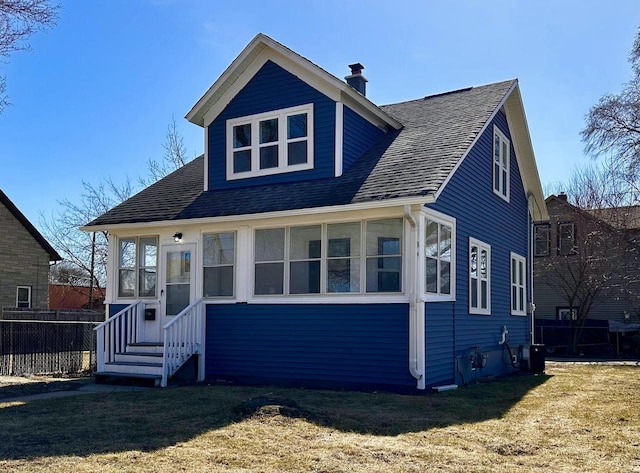 bungalow with central AC unit, a front yard, and a sunroom