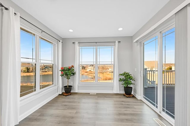 spare room with a healthy amount of sunlight, baseboards, and light wood finished floors