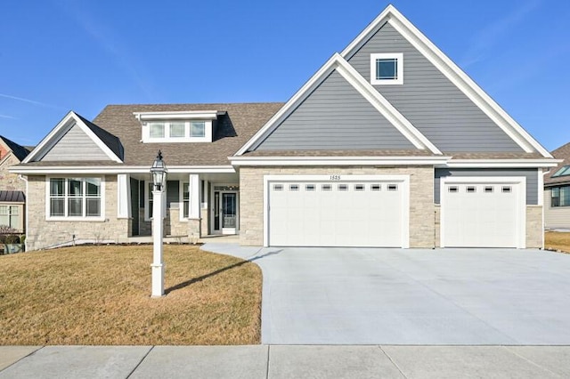 craftsman house with stone siding, driveway, a front lawn, and a garage