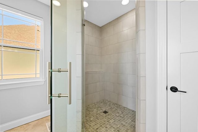 bathroom with baseboards and a shower stall