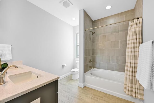 full bathroom featuring visible vents, toilet, wood finished floors, shower / tub combo, and baseboards