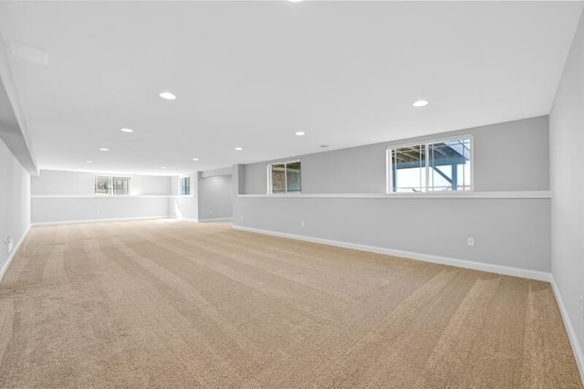 below grade area featuring recessed lighting, baseboards, and light carpet