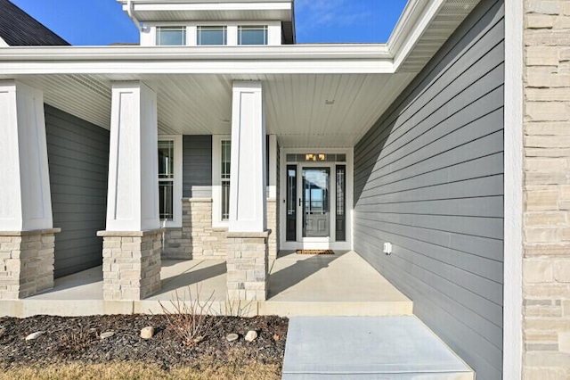 entrance to property featuring covered porch and stone siding