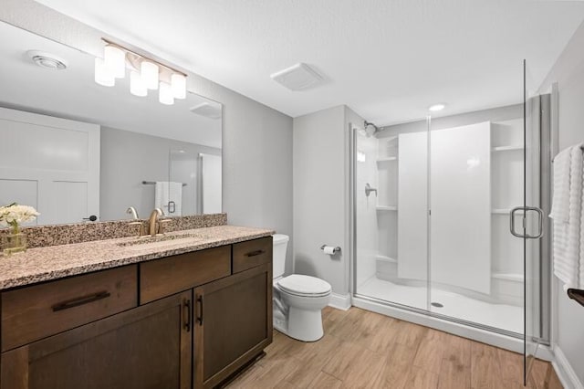 full bath with vanity, toilet, wood finished floors, and a shower stall