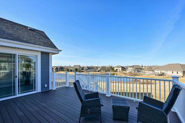 wooden terrace featuring a residential view and a water view