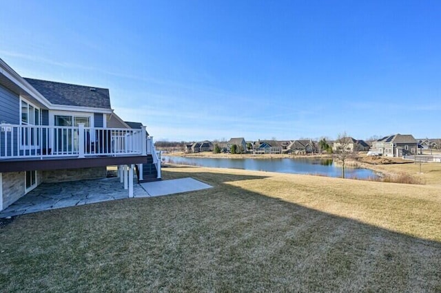 view of yard featuring a deck with water view, a patio, and a residential view