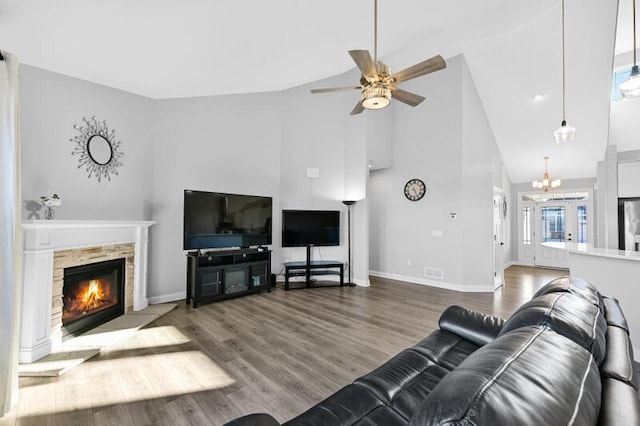 living area featuring visible vents, a fireplace, baseboards, and wood finished floors