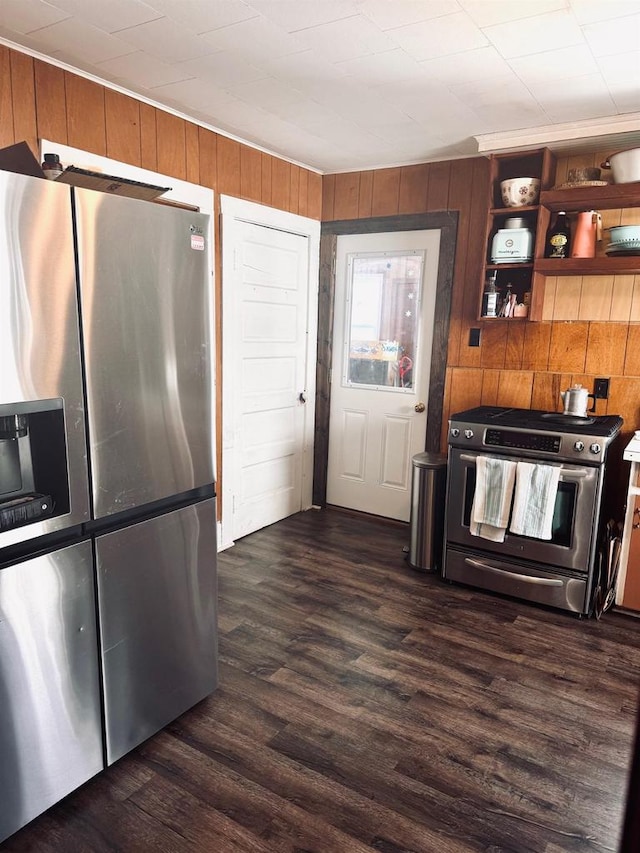 kitchen featuring dark wood finished floors, wood walls, and stainless steel appliances