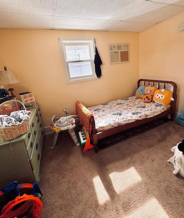 bedroom featuring baseboards, a paneled ceiling, carpet flooring, and a wall unit AC