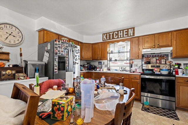 kitchen with under cabinet range hood, stainless steel appliances, and brown cabinets