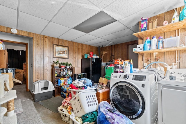 laundry room with laundry area, independent washer and dryer, and wood walls