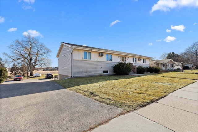 ranch-style house with aphalt driveway and a front yard