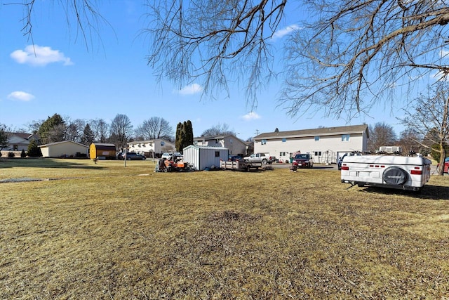 view of yard with a residential view, a storage unit, and an outdoor structure