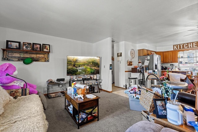 living area featuring baseboards, light carpet, and a ceiling fan