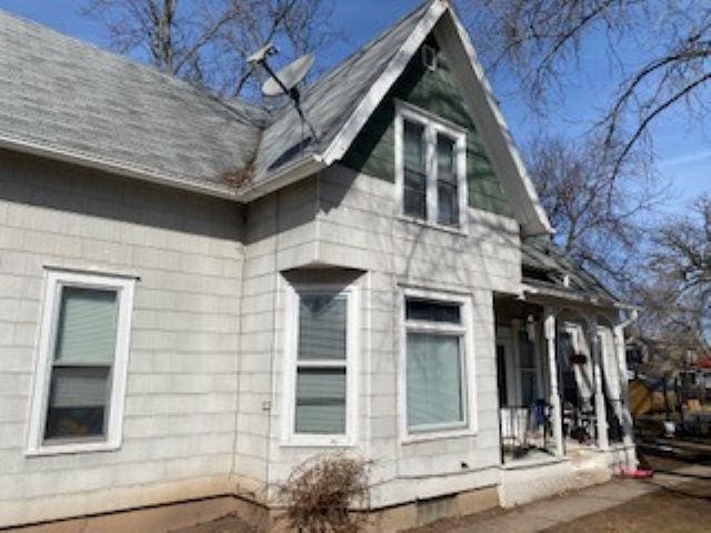 view of side of home featuring roof with shingles