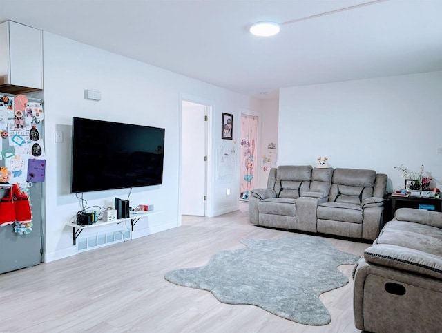 living room with baseboards and light wood-style floors