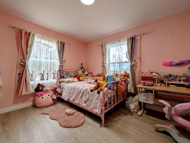 bedroom featuring baseboards and wood finished floors